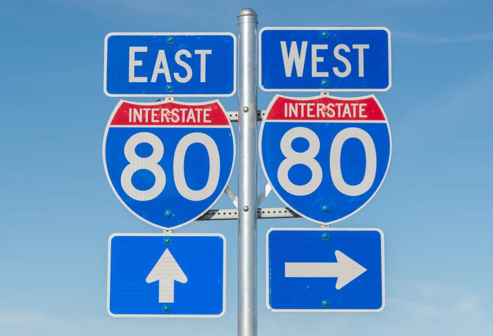 Una señal de tráfico que indica una carretera interestatal que va hacia el este y una carretera interestatal que va hacia el oeste.