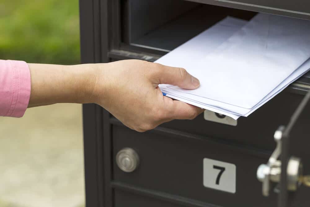 Mujer que recibe un cheque de reembolso de una escuela en línea por correo