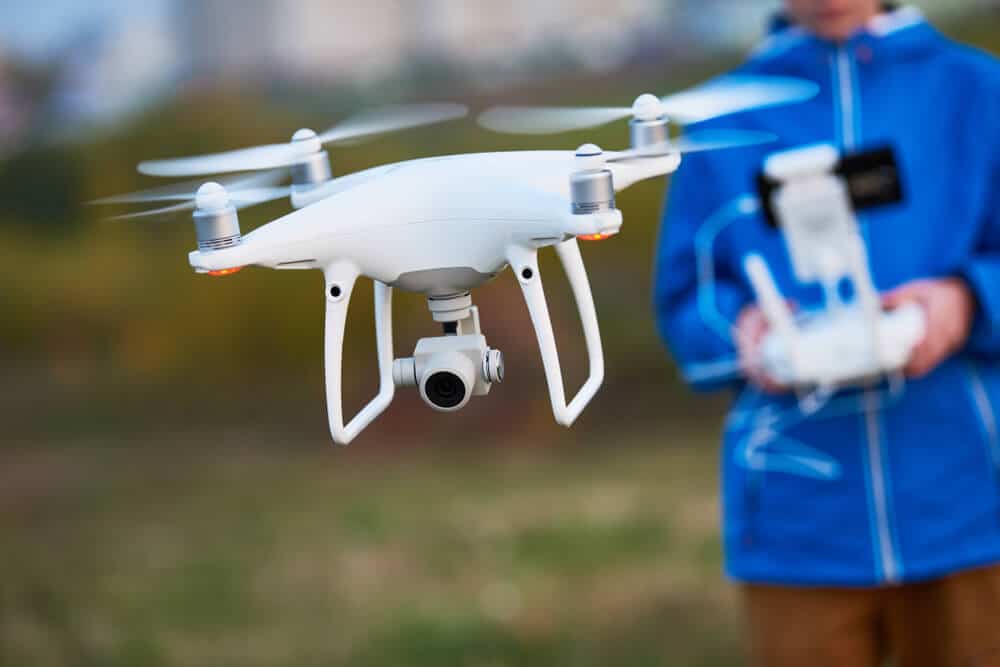 Persona con chaqueta azul volando un dron