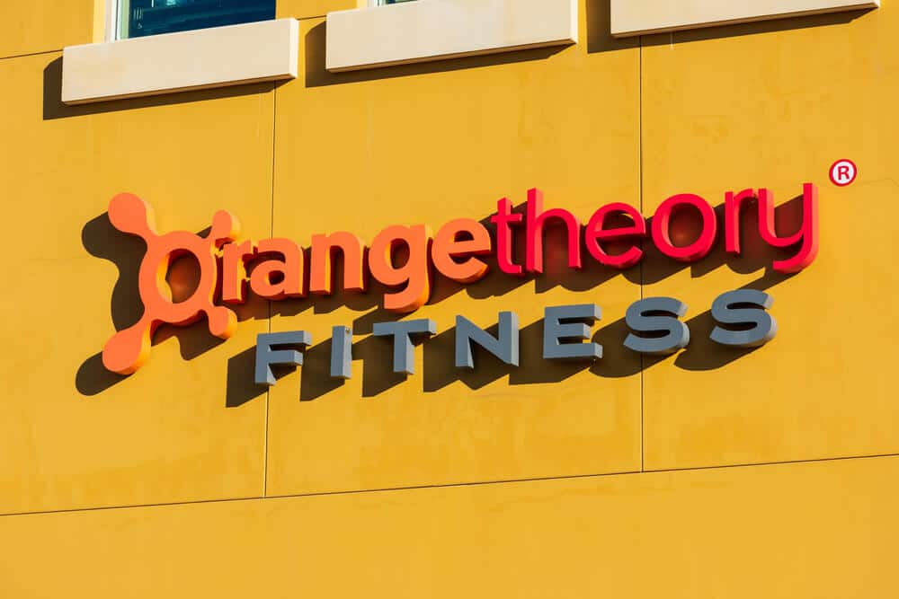 Signo del logotipo de Orangetheory Fitness en el exterior de un edificio amarillo