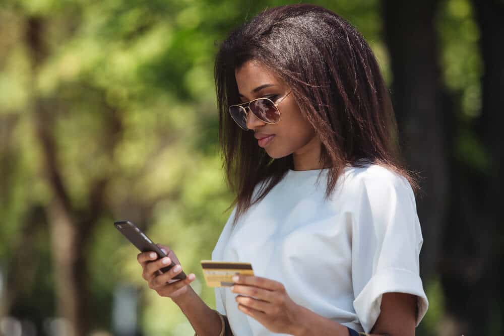 Mujer joven que usa una tarjeta de crédito de estudiante para comprar en línea