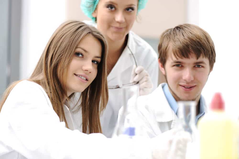 Un grupo de estudiantes de biología trabajando en una mesa de laboratorio.