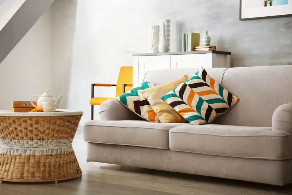 Salón amueblado con sofá beige y cojines de colores