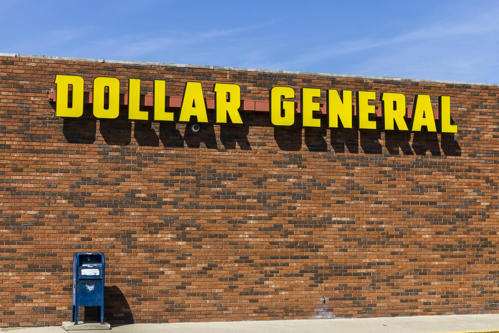 signo general de dólar amarillo contra una pared de ladrillos