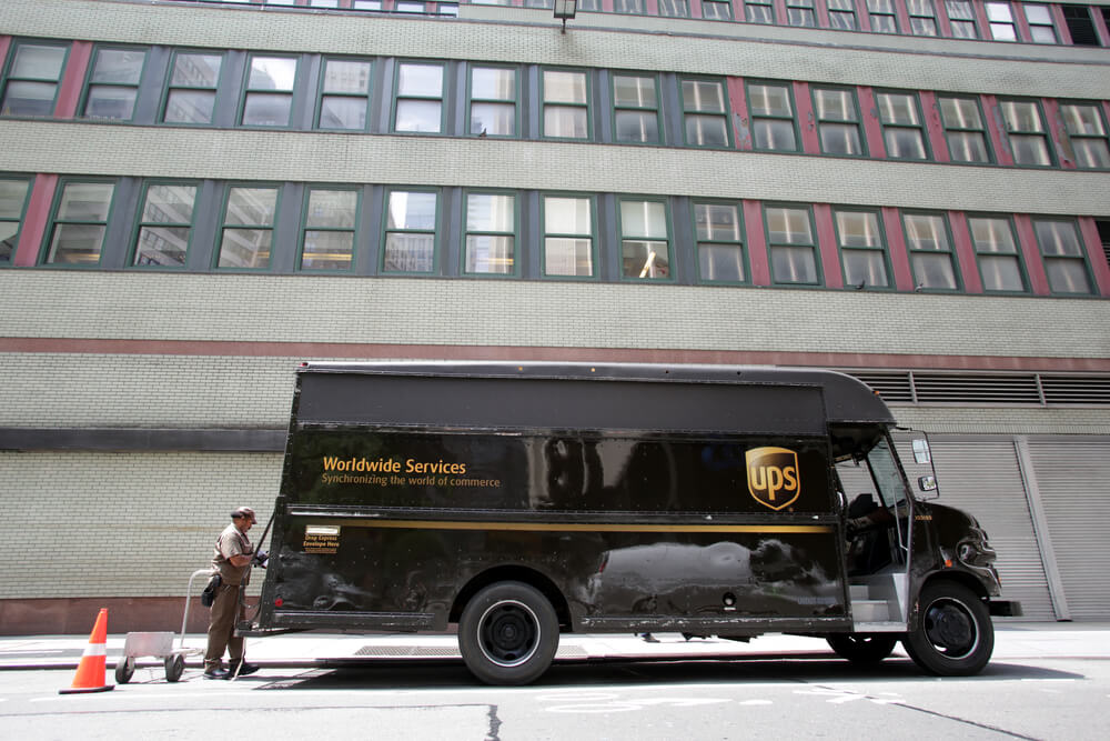 Un camión de reparto de UPS y un conductor fuera de un edificio.