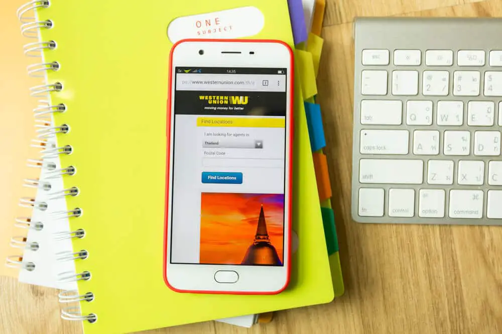 Cuaderno, teclado y teléfono con página de Western Union