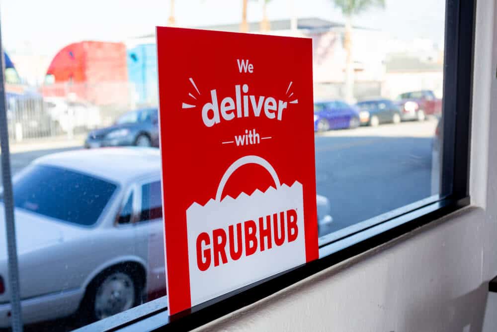 Cartel de "Entregamos con Grubhub" en la ventana de un restaurante
